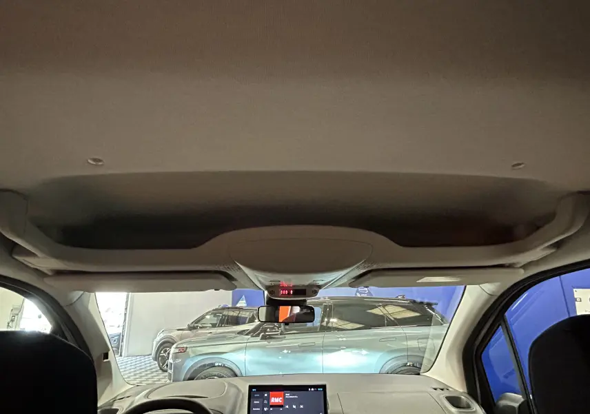 Vue intérieure du Citroën Berlingo Multispace 2026, avec tableau de bord et pare-brise montrant un SUV gris acier à l'extérieur.