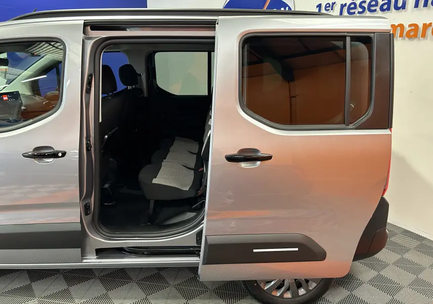 Vue latérale droite du Citroën Berlingo Multispace gris acier avec porte coulissante ouverte dévoilant les sièges arrière.