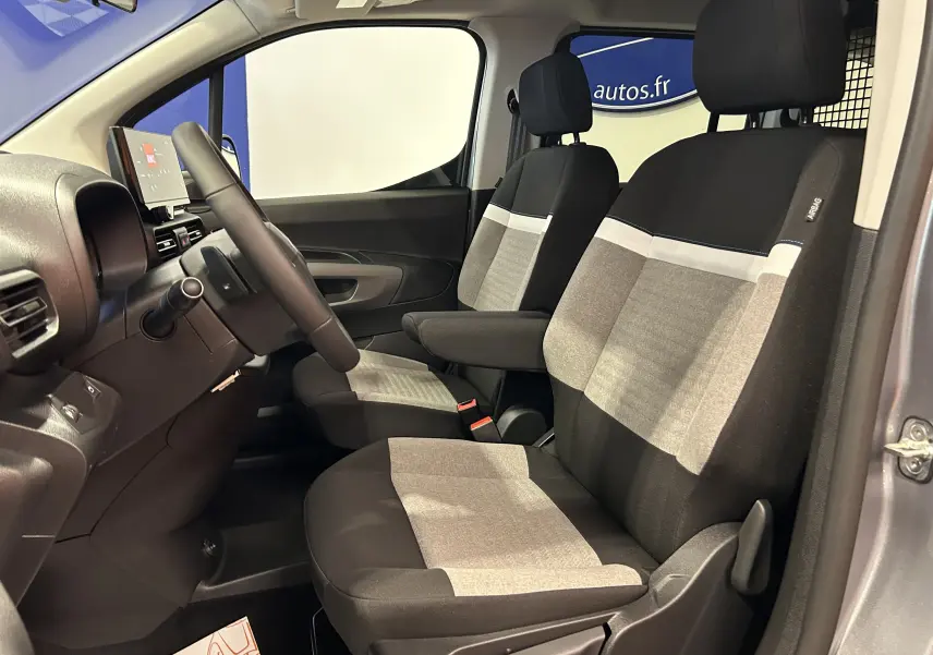Intérieur avant du Citroën Berlingo Multispace gris acier, sièges tissu bicolore avec accoudoir central côté conducteur.