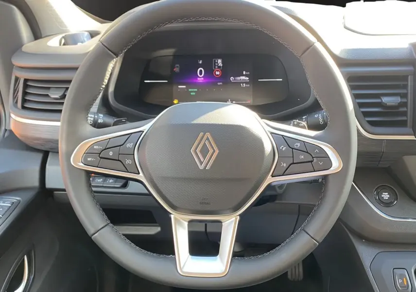 Vue rapprochée du volant noir et du tableau de bord digital du Renault Trafic Combi 2025 avec commandes intégrées.