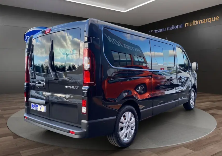 Renault Trafic Combi noir vu en 3/4 arrière droit, porte latérale coulissante et vitres teintées visibles.