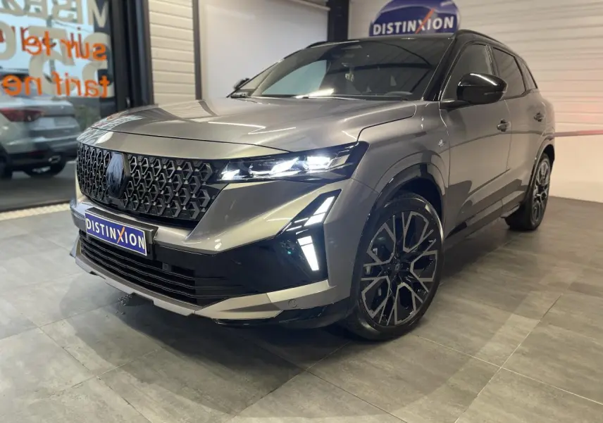 Renault Austral 2025 gris schiste métallisé avec toit noir étoilé, vue 3/4 avant droit mettant en valeur la calandre et les phares LED.