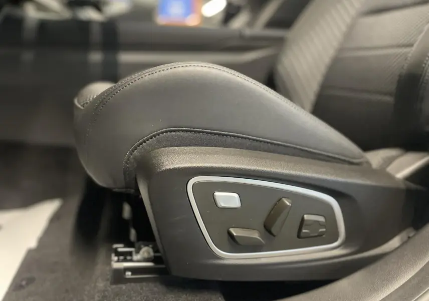 Gros plan sur les commandes électriques du siège avant droit en cuir noir du Renault Austral 2025.