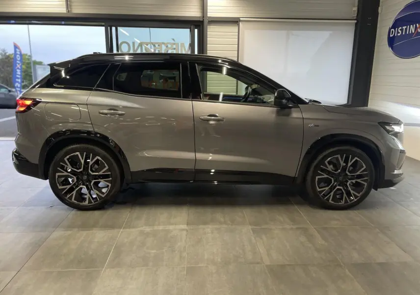 Profil droit du Renault Austral 2025 gris schiste métallisé avec toit noir étoilé et jantes noires distinctives.