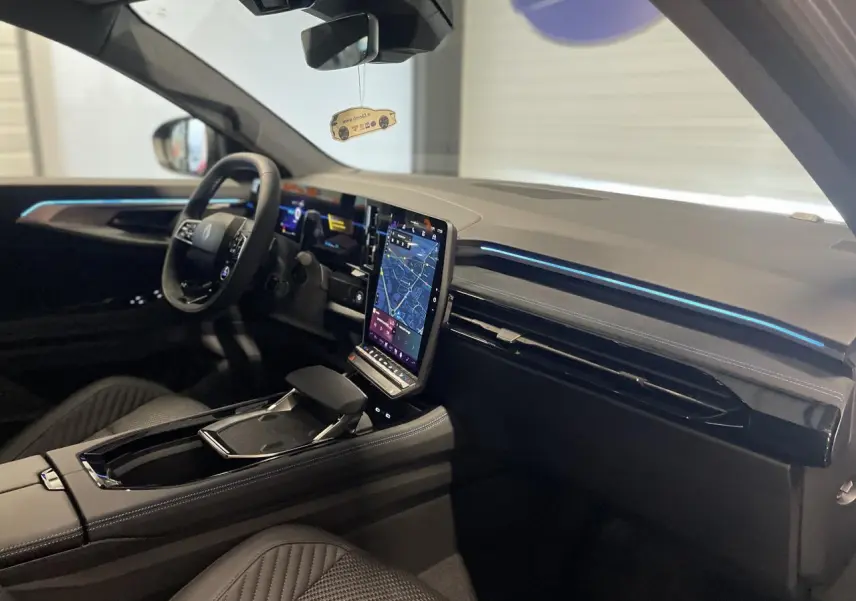Vue intérieure côté conducteur du Renault Austral 2025 avec écran tactile vertical et ambiance moderne noire.