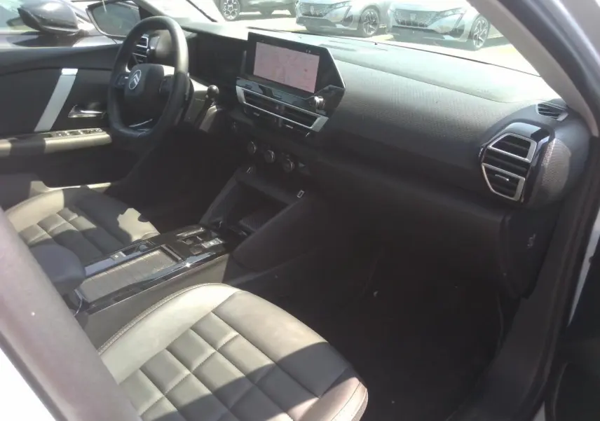 Intérieur avant droit de la Citroën C4 Hybrid blanc Okénite, avec tableau de bord numérique et écran tactile central.