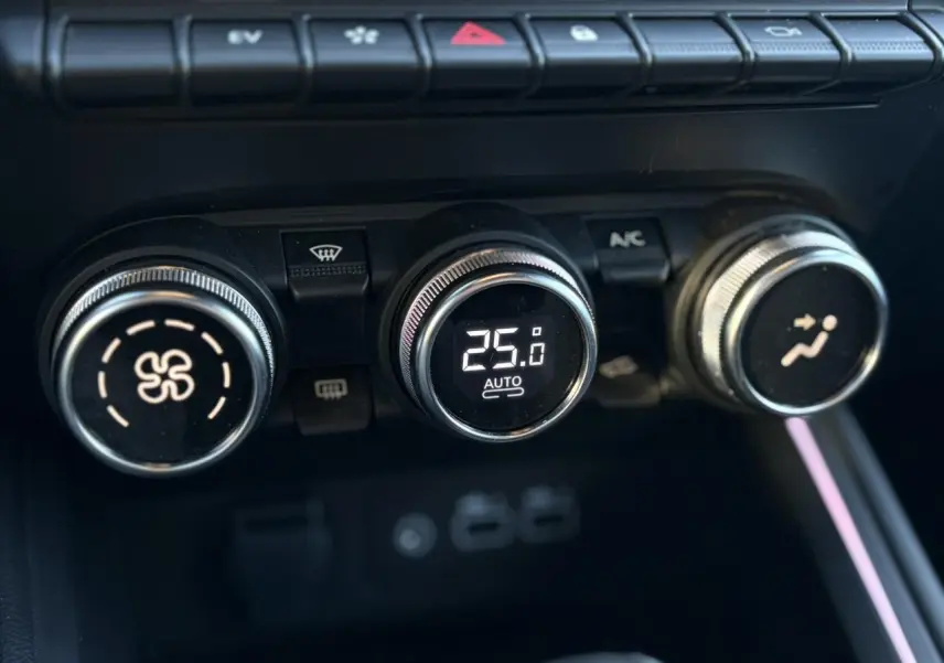 Gros plan sur les commandes de climatisation automatique de la Renault Clio V E-Tech, avec affichage digital à 25°C.