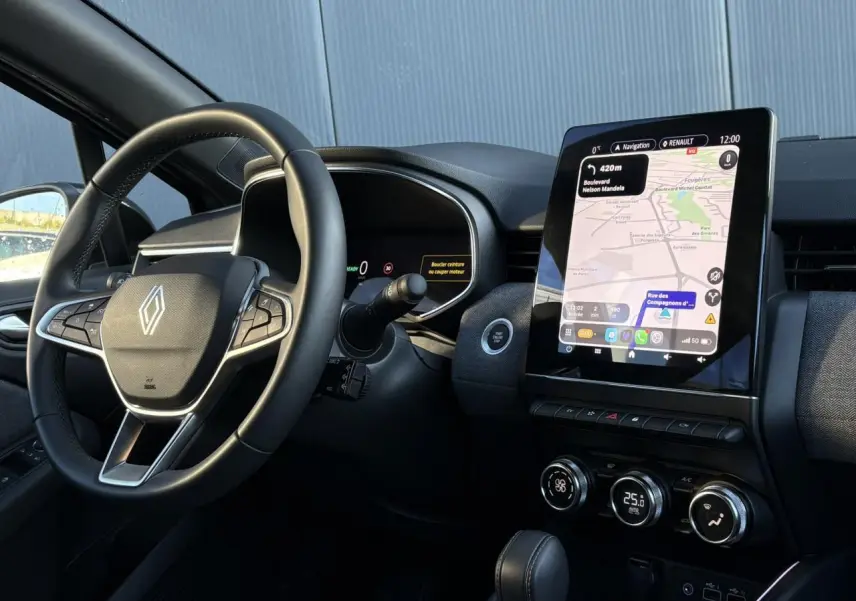 Vue intérieure côté conducteur de la Renault Clio V E-Tech 145 Techno, avec volant multifonction et écran tactile 9,3 pouces.