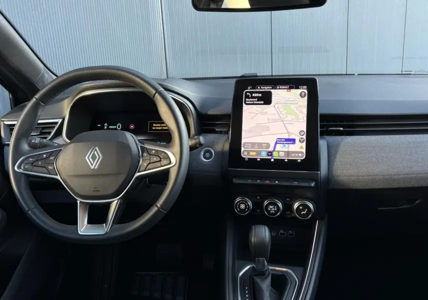 Vue intérieure frontale du tableau de bord de la Renault Clio Gris Schiste avec écran tactile vertical et volant multifonction.