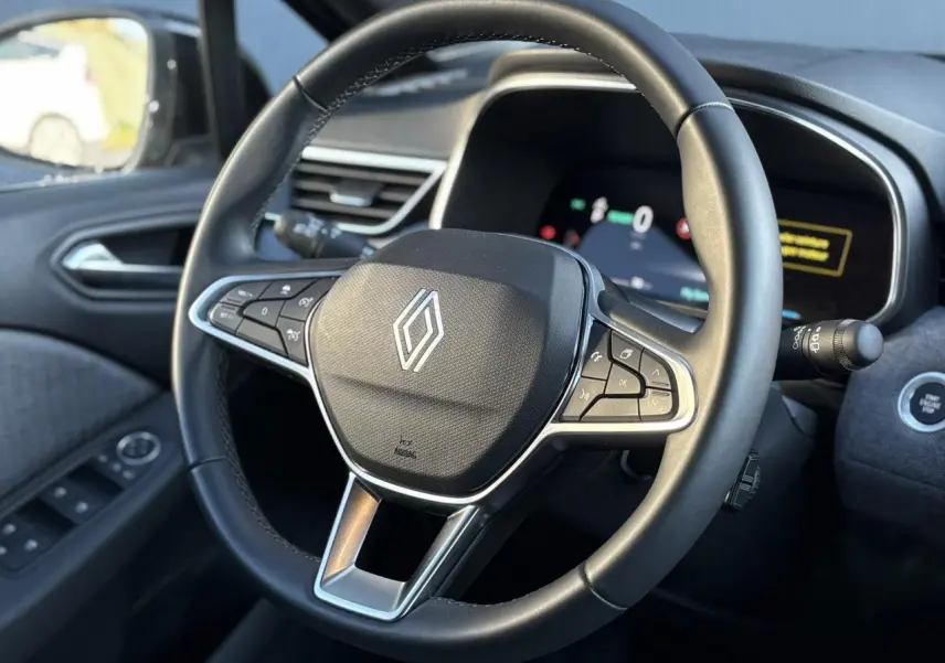 Vue rapprochée du volant noir de la Renault Clio V E-Tech 2025 avec commandes intégrées et tableau de bord numérique.
