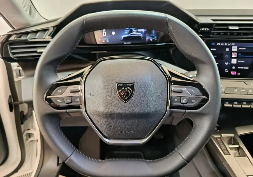 Vue rapprochée du volant cuir noir de la Peugeot 308 2022 avec affichage digital et commandes multifonctions.