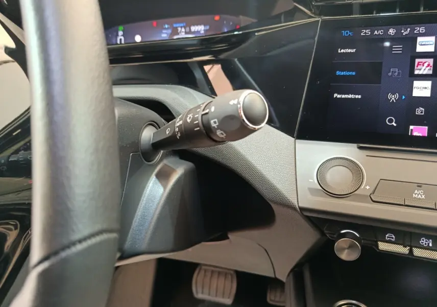 Vue intérieure rapprochée du tableau de bord et volant noir de la Peugeot 308 2022 avec écran tactile et commandes digitales.