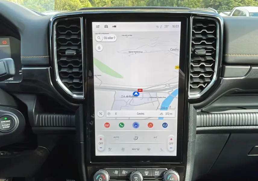 Vue intérieure centrée sur l’écran tactile vertical du Ford Ranger Wildtrak 2025 avec tableau de bord noir et finitions jaunes.