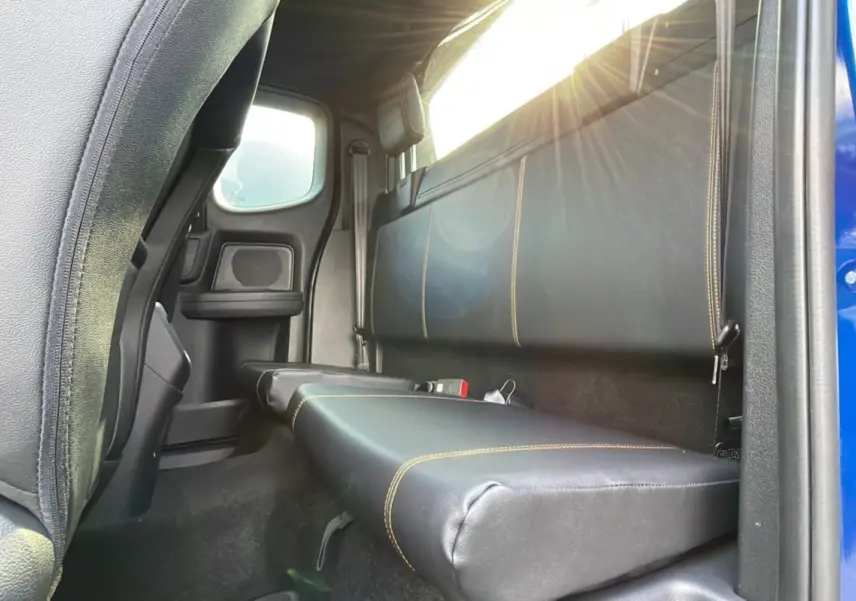Vue intérieure arrière côté droit du Ford Ranger 2.0 205 Wildtrak Supercab bleu lightning, banquette en cuir noir avec surpiqûres jaunes.