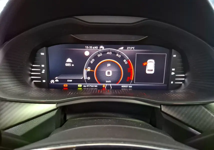 Vue rapprochée du tableau de bord numérique du Skoda Kamiq blanc, affichant la vitesse à 0 km/h et divers indicateurs.