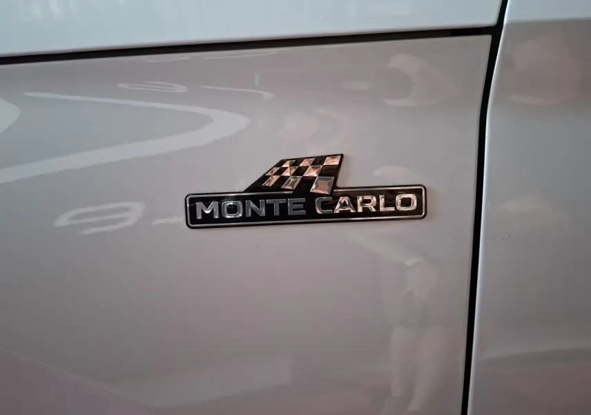 Gros plan sur l’écusson Monte Carlo noir et argent sur la portière blanche d’un Skoda Kamiq 2021.