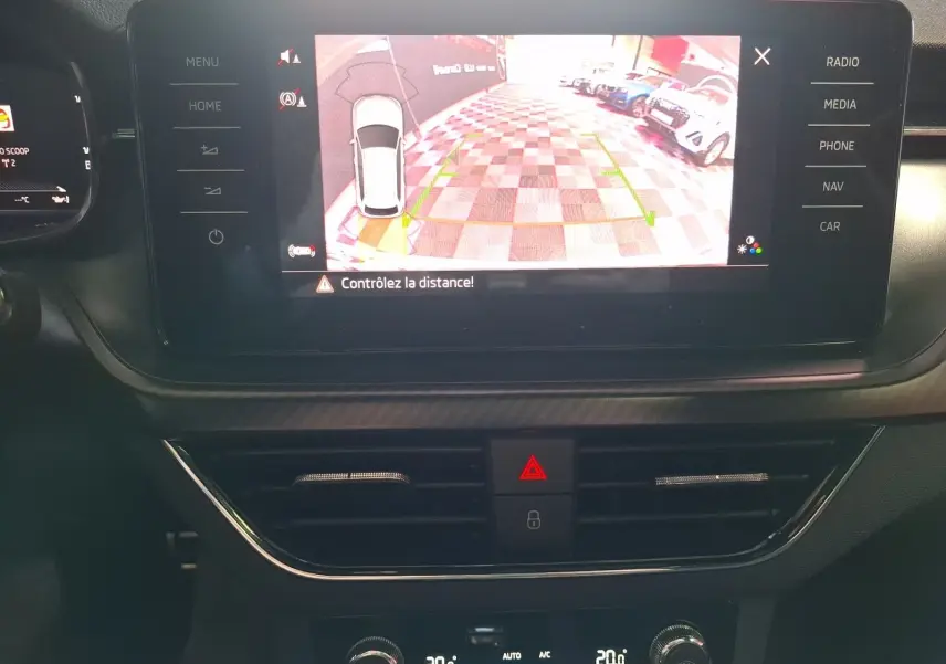 Écran central du Skoda Kamiq blanc 2021 montrant la caméra de recul avec alertes de distance, vue intérieure.