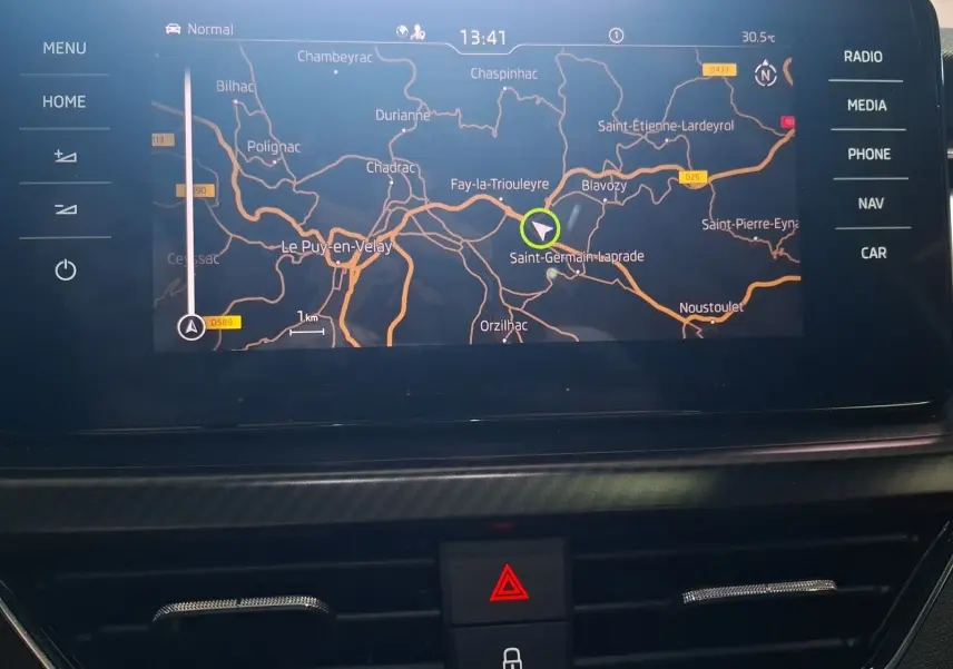 Écran GPS du Skoda Kamiq 2021 affichant une carte routière avec options tactiles autour, vue intérieure frontale.