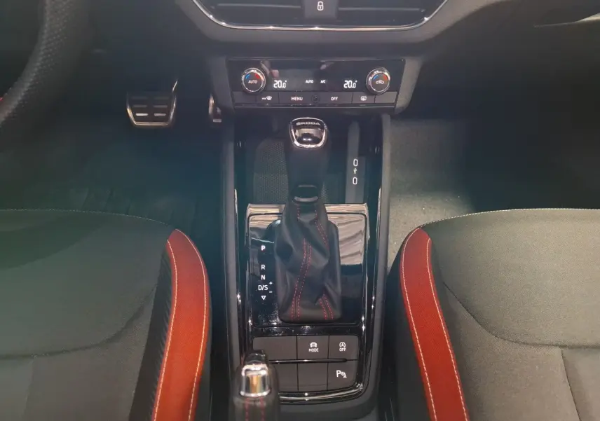 Vue rapprochée de la console centrale du Skoda Kamiq blanc 2021, avec levier de boîte auto et surpiqûres rouges.