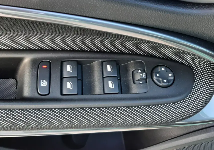 Gros plan sur les commandes de lève-vitres et rétroviseurs côté gauche intérieur d'une FIAT 600 1.2 Hybrid 2025.