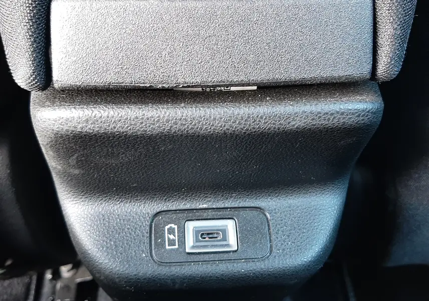 Prise USB de recharge située à l'arrière de la console centrale, intérieur noir du FIAT 600 Vert Sky 2025.