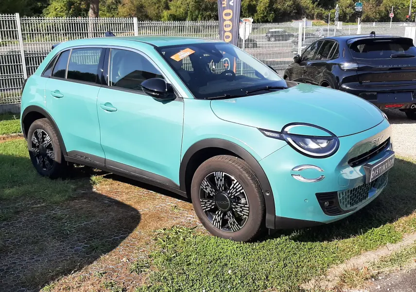 Vue 3/4 avant gauche d'une FIAT 600 1.2 Hybrid 136ch DCT6 vert sky avec jantes noires et détails noirs contrastants.