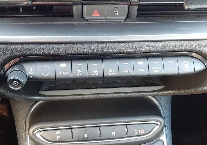 Vue rapprochée de la console centrale de la FIAT 600 1.2 Hybrid 2025, montrant les commandes de climatisation et la boîte automatique.