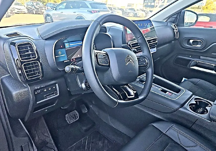 Intérieur du Citroën C5 Aircross 2024, vue côté conducteur, volant cuir multifonction et tableau de bord digital.