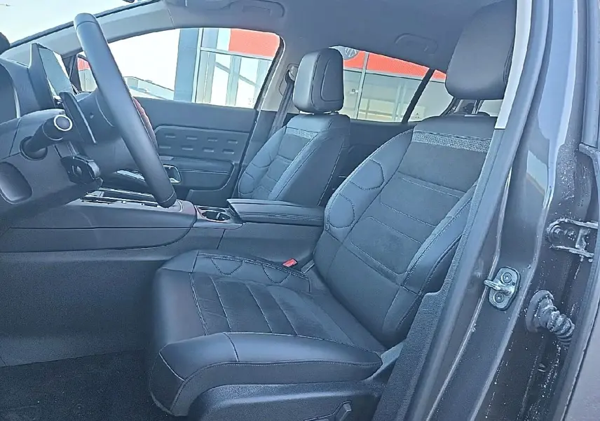 Vue intérieure côté conducteur du Citroën C5 Aircross gris platinium, montrant les sièges avant en cuir noir et le volant multifonction.