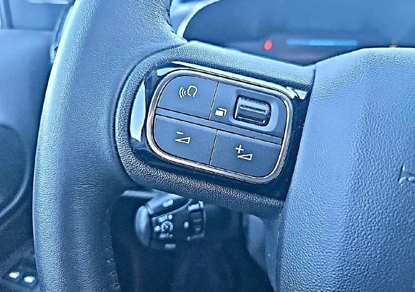 Gros plan sur les commandes gauche du volant cuir multifonction du Citroën C5 Aircross gris platinium 2024.