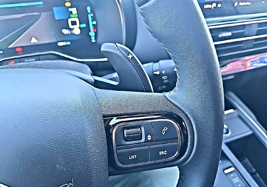 Gros plan sur le volant cuir multifonction noir du Citroën C5 Aircross 2024 avec commandes intégrées et palettes au volant.