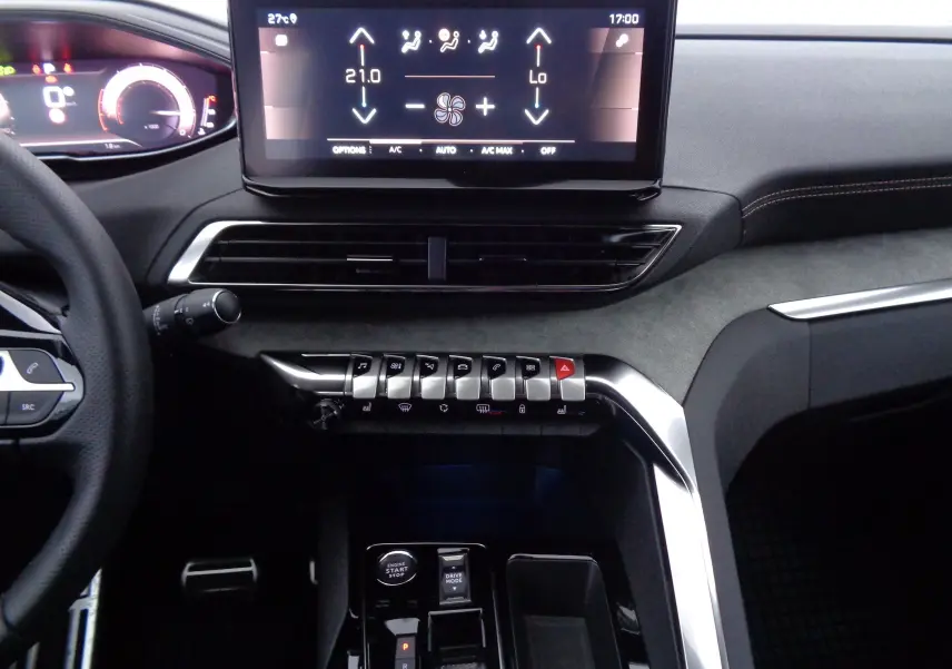 Tableau de bord et console centrale du Peugeot 3008 GT 2023, avec écran tactile et commandes argentées sur fond gris anthracite.