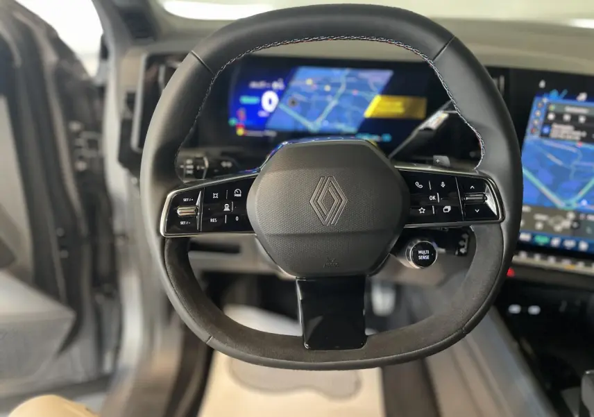 Volant Alcantara avec logo Renault au centre, vue frontale intérieure du tableau de bord numérique du Renault Austral 2025.