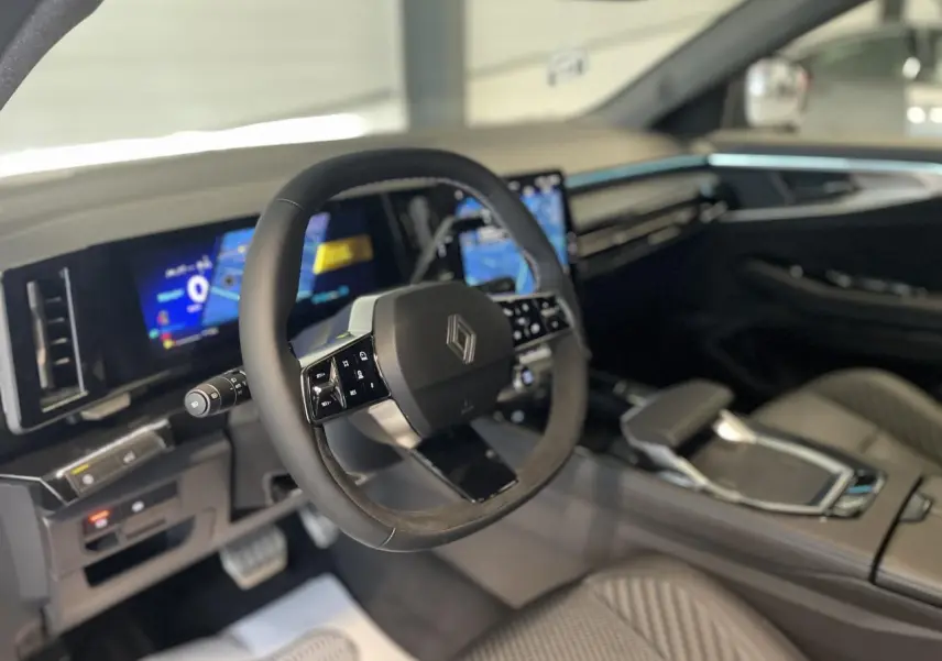 Intérieur du Renault Austral 2025 vu côté conducteur, volant Alcantara et tableau de bord numérique lumineux.