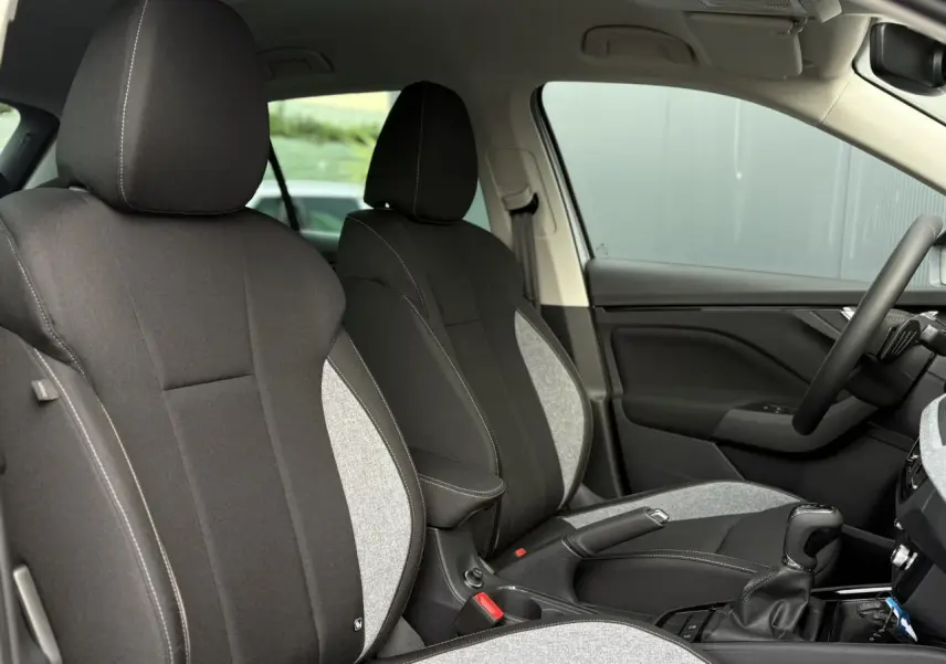 Vue intérieure côté droit montrant les sièges bicolores noirs et gris du Skoda Kamiq 2025 avec accoudoir central.