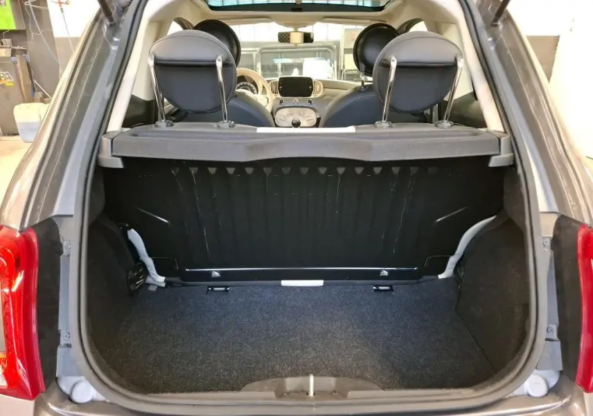 Vue arrière du coffre ouvert d'une FIAT 500 Gris Electroclash 2022, avec intérieur noir et planche de séparation visible.