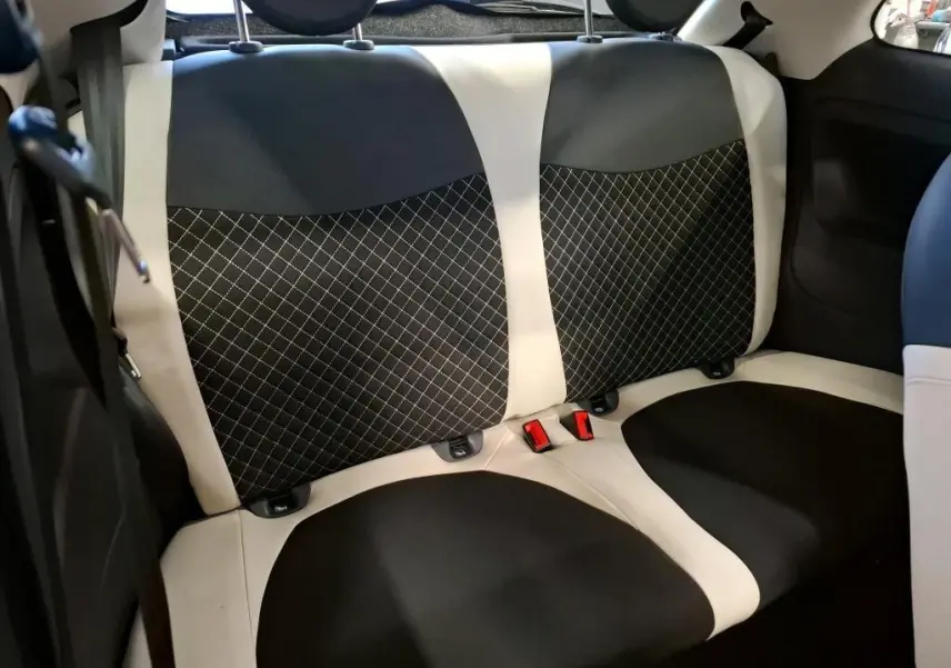 Vue rapprochée des sièges arrière bicolores noir et blanc de la Fiat 500 Dolcevita 2022, avec surpiqûres croisées.