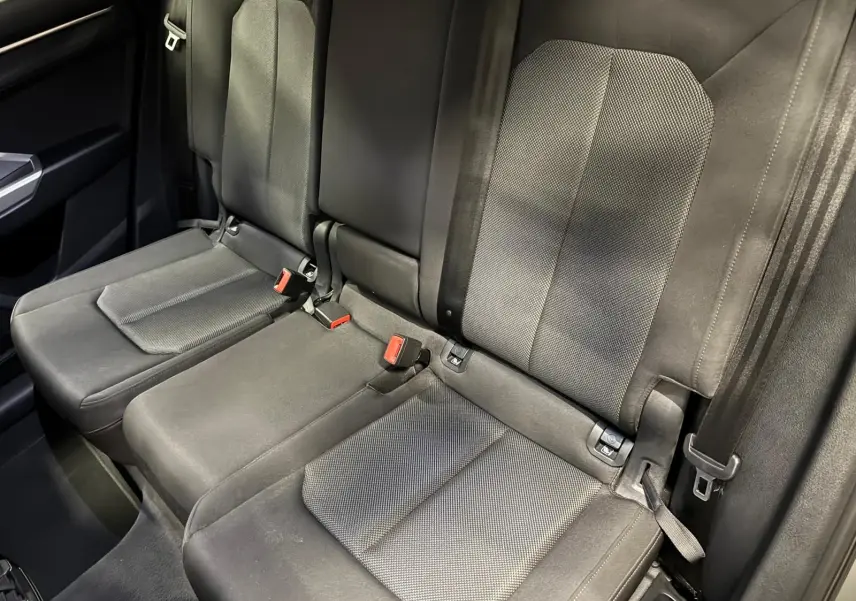 Vue rapprochée des sièges arrière en tissu gris du SUV Audi Q3 Business, avec fixations Isofix visibles.