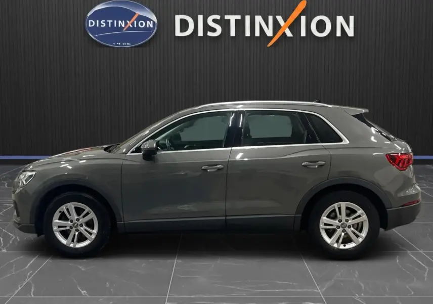 Profil droit d'un Audi Q3 Business gris 2019, mettant en valeur ses jantes alliage et feux arrière LED.