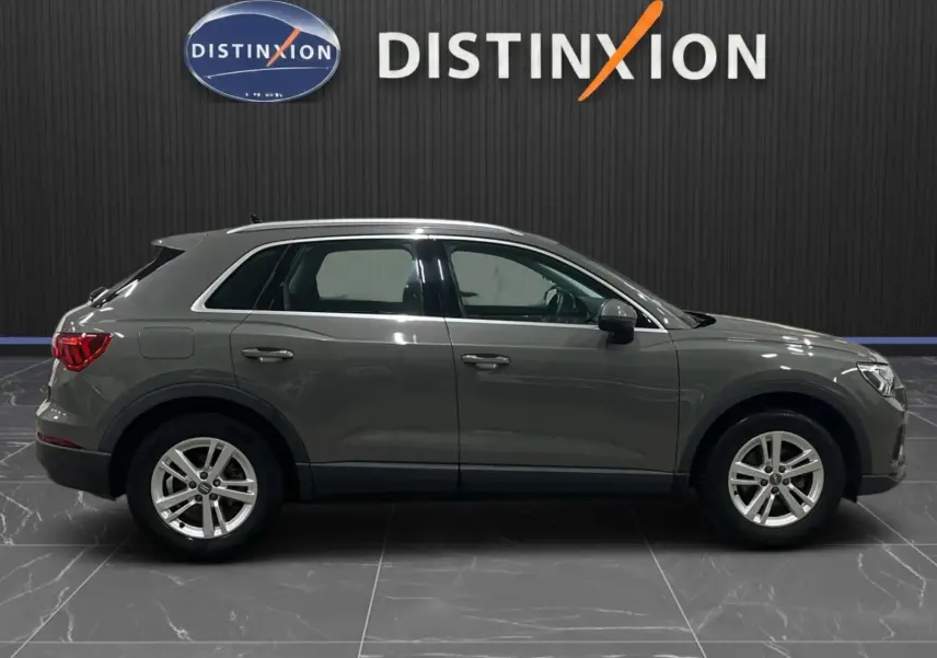 Vue latérale droite d'un Audi Q3 Business gris de 2019 avec jantes alliage et feux arrière LED dynamiques.