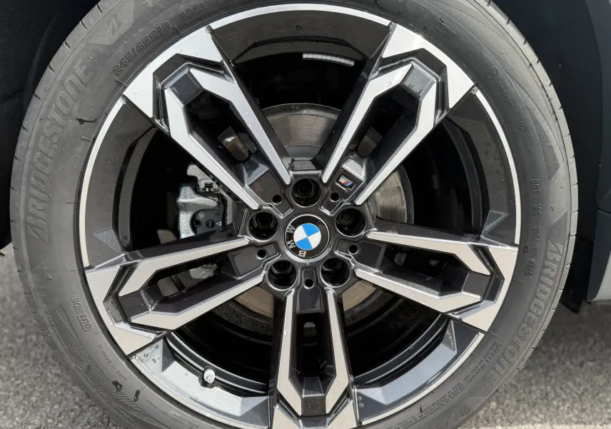 Gros plan sur la jante alliage 19 pouces bicolore d'une BMW X2 Skyscraper, mettant en valeur le logo M Sport central.