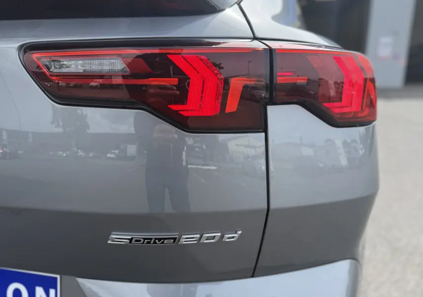 Gros plan sur le feu arrière droit rouge et la partie arrière grise métallisée du BMW X2 2.0DA 163 CH M SPORT 2025.
