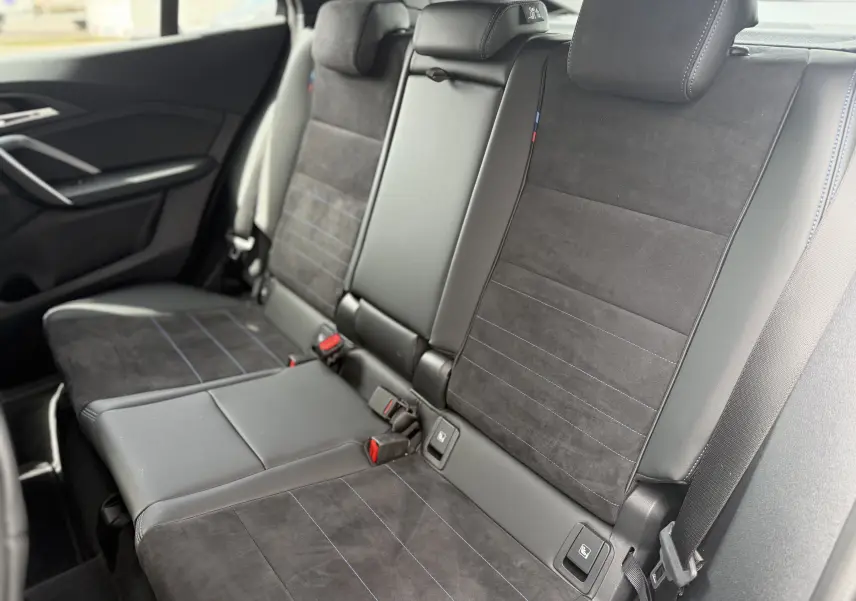 Vue intérieure des sièges arrière en cuir et alcantara noirs avec surpiqûres bleues d'une BMW X2 2025 Skyscraper.