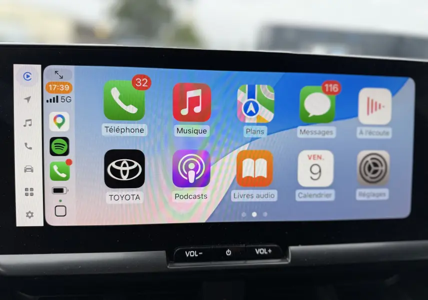 Écran tactile central du Toyota C-HR Hybride 2024 affichant l'interface Apple CarPlay avec icônes colorées.