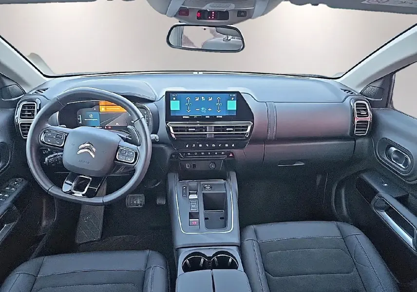 Vue intérieure avant du Citroën C5 Aircross 2024, tableau de bord et volant multifonction en cuir noir.