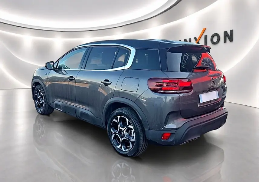 Citroën C5 Aircross gris platinium en 3/4 arrière droit, avec jantes alu et vitres arrière teintées.