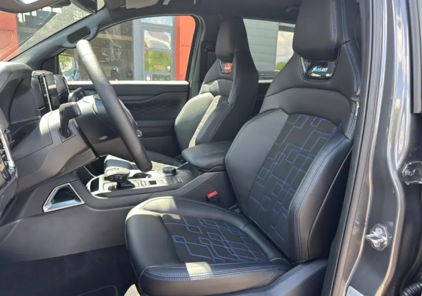Intérieur du Ford Ranger 3.0 V6 gris carbone, vue côté conducteur, sièges sport noirs avec surpiqûres bleues MS-RT.