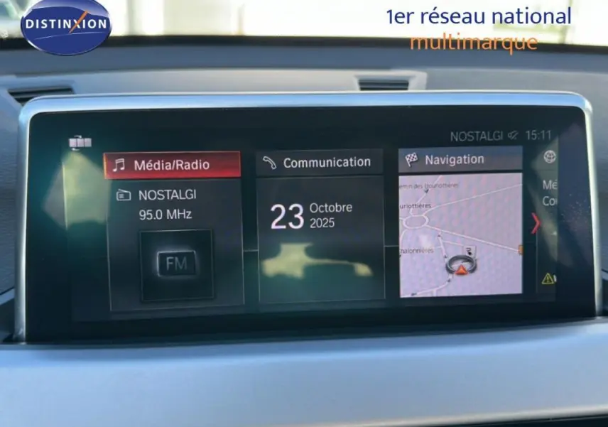 Écran central de la BMW X1 F48 LCI 2022 affichant radio, communication et navigation, intérieur gris clair.