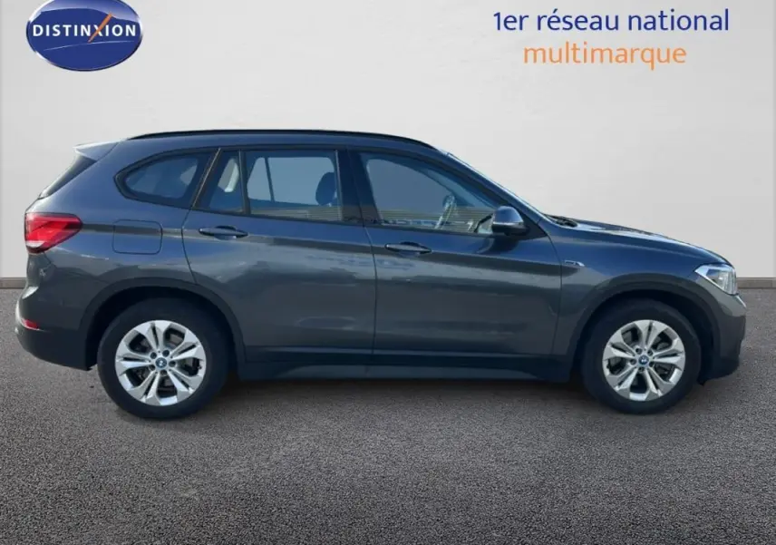 BMW X1 F48 LCI gris foncé vue de profil côté gauche avec jantes alliage 18 pouces sur fond neutre.