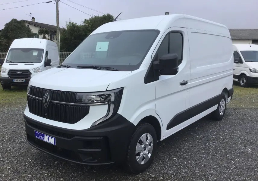 Vue 3/4 avant droit d’un utilitaire Renault Master blanc avec calandre noire et jantes argentées sur parking extérieur.